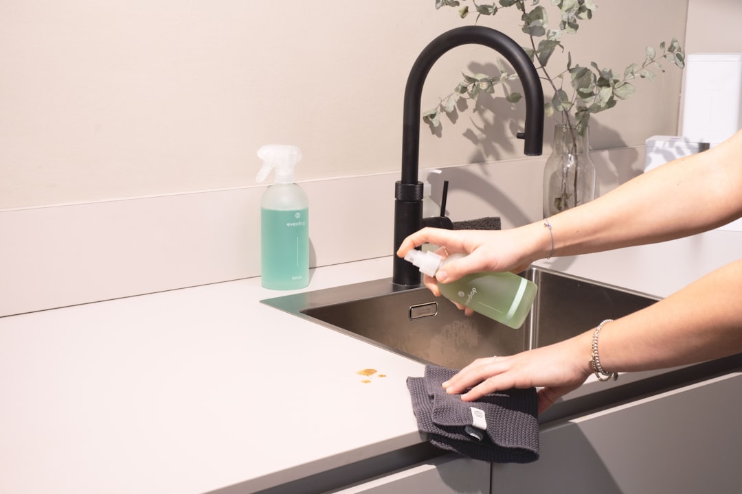 services-01 a-woman-is-cleaning-a-kitchen-sink-with-a-rag-sqomdoqb3ws
